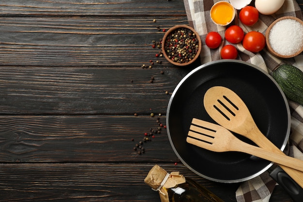 Composizione con ingredienti per cucinare su fondo in legno, vista dall'alto