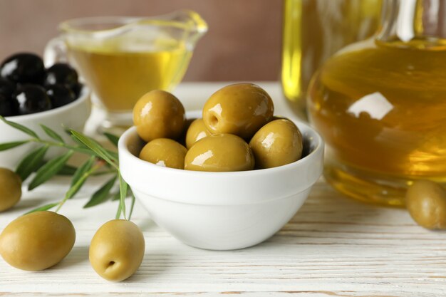 Composizione con olio d'oliva e olive sulla tavola di legno, fine su