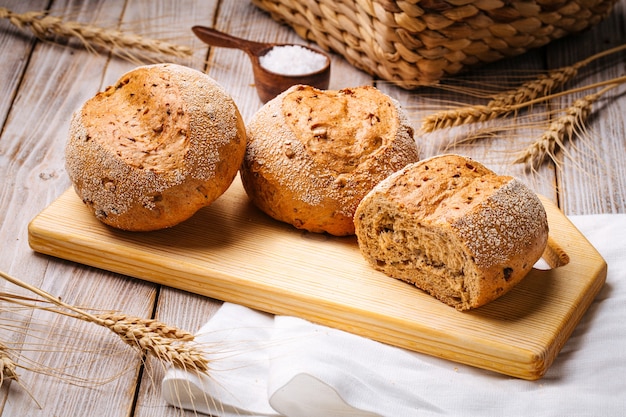 Composizione con pagnotte di pane di frumento sul tavolo di legno