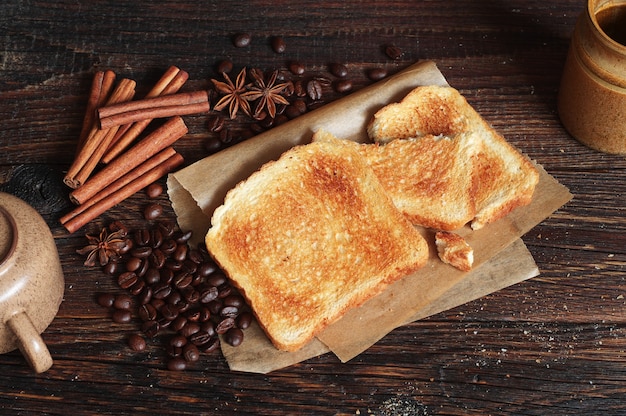 Composizione con pane tostato e oggetti diversi su vecchio tavolo in legno