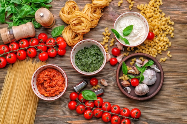 Composizione con pesto alla bolognese e salse bianche per pasta in ciotole sul tavolo