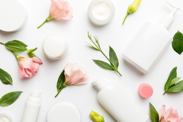 Composizione con prodotti cosmetici e belle rose su sfondo bianco