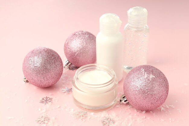 Composizione con prodotti cosmetici invernali su sfondo rosa