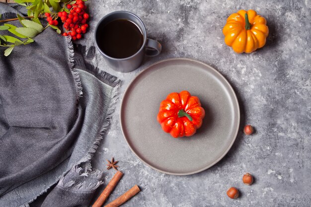 Composizione con tazza con caffè, foglie di autunno, zucche, spezie su calcestruzzo