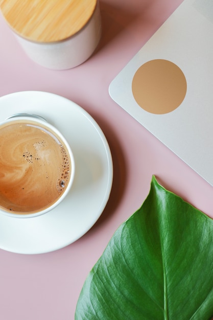 Composizione con tazza di caffè, computer portatile, libro e zucchero