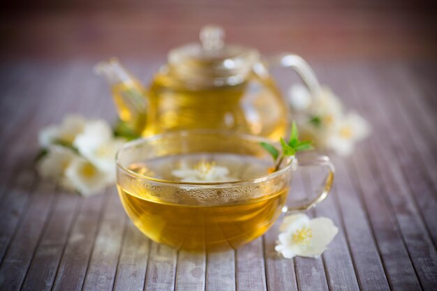 Composizione con tazza di tè al gelsomino e fiori su uno sfondo di bambù