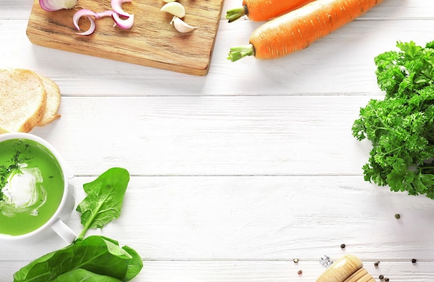 Composizione con una deliziosa zuppa di spinaci e spezie su fondo di legno