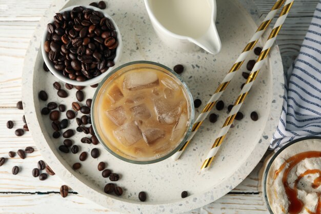 Composizione con vassoio con caffè ghiacciato su fondo in legno