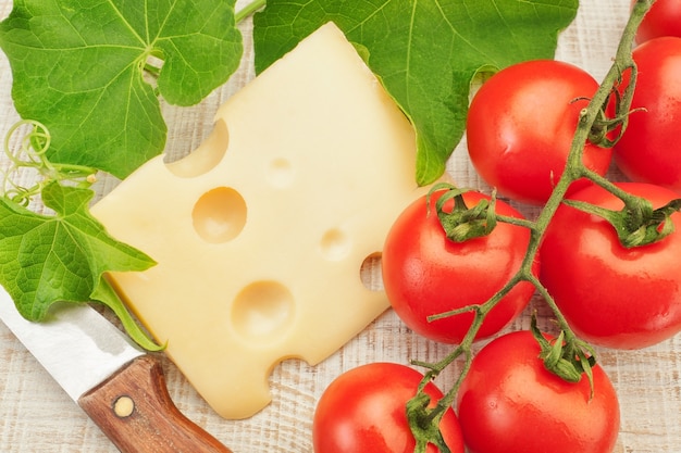 Composizione con verdure e coltello da formaggio per tagliare.