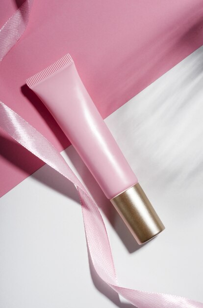 Composizione cosmetica rosa tubo e nastro rosa vista dall'alto Crema idratante prodotto cosmetologia cura della pelle