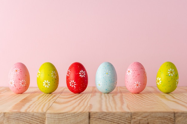 Composizione creativa con le uova di Pasqua sulla tavola di legno.