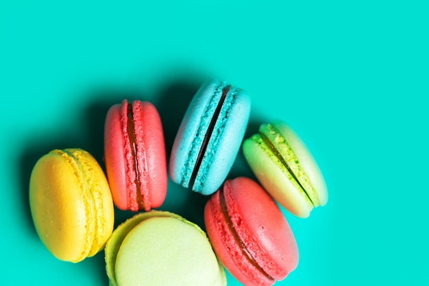 Composizione creativa con torta macaron o amaretto su sfondo blu pastello, vista dall'alto, primo piano