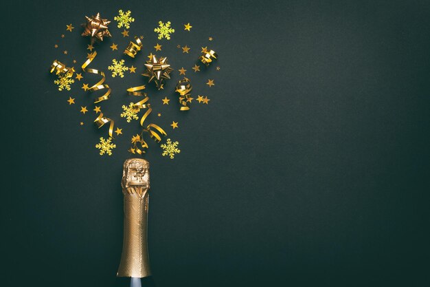 Composizione creativa piatta con bottiglia di champagne e spazio per il testo su sfondo colorato Bottiglia di champagne con festa colorata di stelle filanti o concetto di Natale