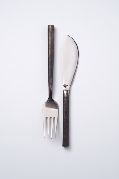 Composizione da forchetta e coltello in metallo vintage su sfondo grigio con spazio per il testo. Lay piatto