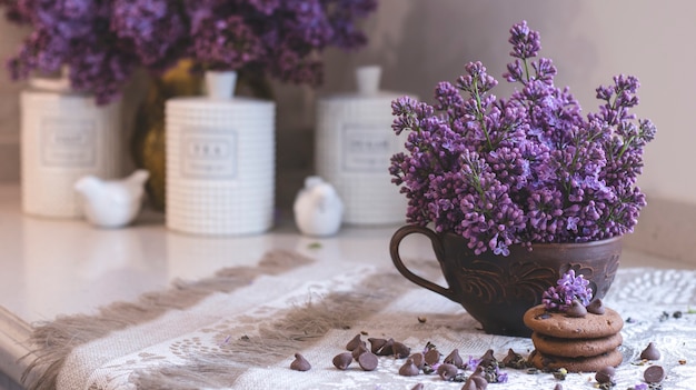 Composizione decorativa con un bouquet di lillà in un interno luminoso della cucina Un bouquet di lillà in un vaso Sfondo floreale primaverile con lillà Estetica