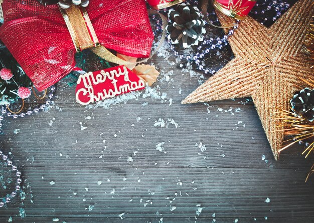 Composizione decorativa di Natale e Capodanno. Vista dall'alto, sfondo con copia spazio per il testo. Stella, coni, fiocchi su un tavolo di legno con la neve.