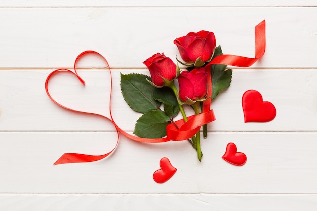 Composizione del giorno di San Valentino con fiore di rosa e cuore rosso sul tavolo Spazio di copia piatto vista dall'alto Concetto di vacanza