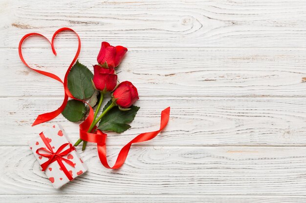 Composizione del giorno di San Valentino con fiore di rosa e cuore rosso sul tavolo Spazio di copia piatto vista dall'alto Concetto di vacanza