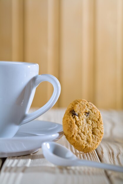 Composizione del primo piano. tazza di caffè blu con cucchiaio e biscotto