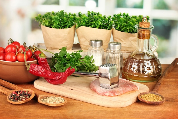 Composizione di carne cruda, verdure e spezie sul primo piano della tavola di legno