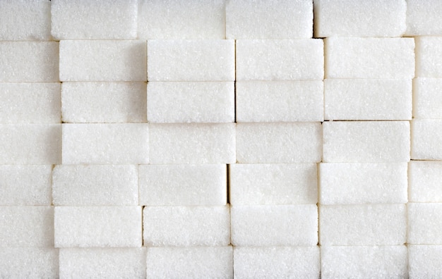 Composizione di cubetti di zucchero bianco di mucchi di mattoni di zucchero ingrediente alimentare malsano caramelle e dolci