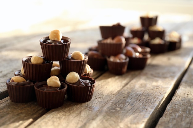 Composizione di diverse caramelle al cioccolato su fondo di legno, primi piani