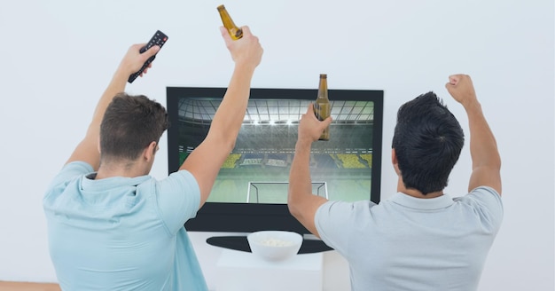 Composizione di due appassionati di sport maschi che guardano lo stadio sportivo in tv