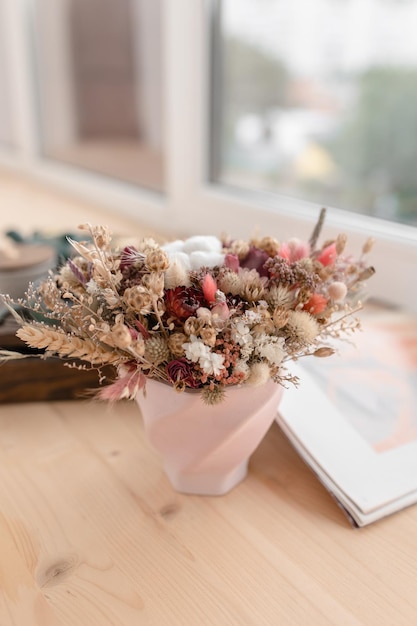 Composizione di fiori secchi in vaso di gesso nei toni del rosa
