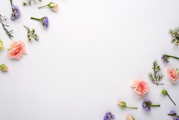 Composizione di fiori vista dall'alto su sfondo bianco, rose rosa, eustoma, limonium negli angoli, lay flat, copia spazio, concetto di infiorescenze