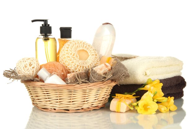 Composizione di flaconi cosmetici e sapone in cesto isolato su bianco