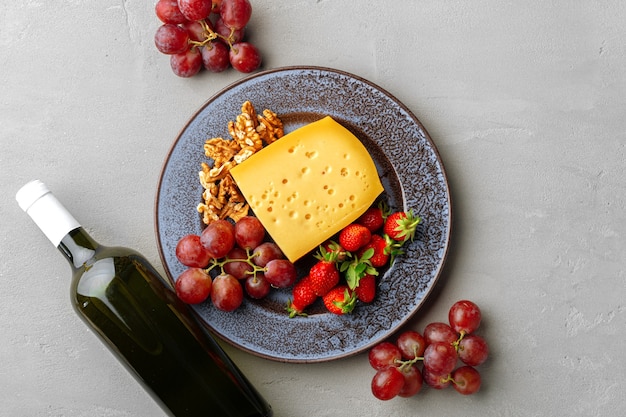 Composizione di formaggio e frutta su sfondo grigio tavolo