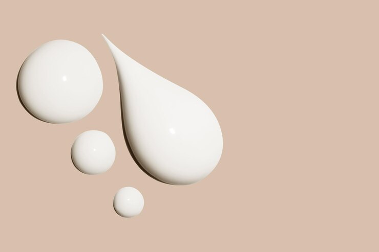 composizione di macchie di crema bianca cosmetica su uno sfondo beige