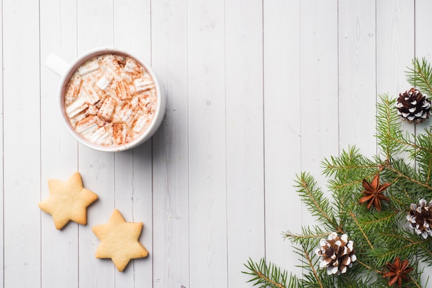 Composizione di Natale, biscotti al cioccolato caldo, rami di pino, bastoncini di cannella, stelle di anice.