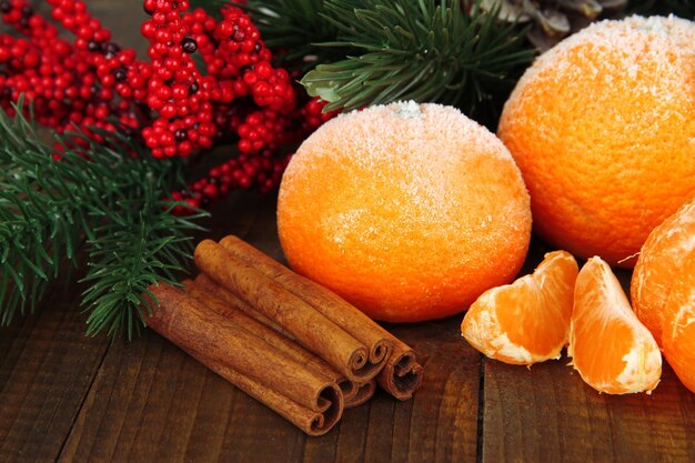 Composizione di Natale con mandarini maturi glassati su fondo di legno