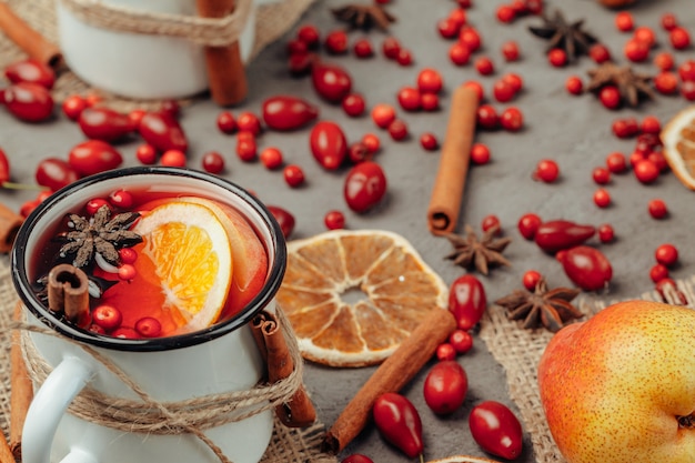 Composizione di natale con vin brulé caldo in tazza rustica