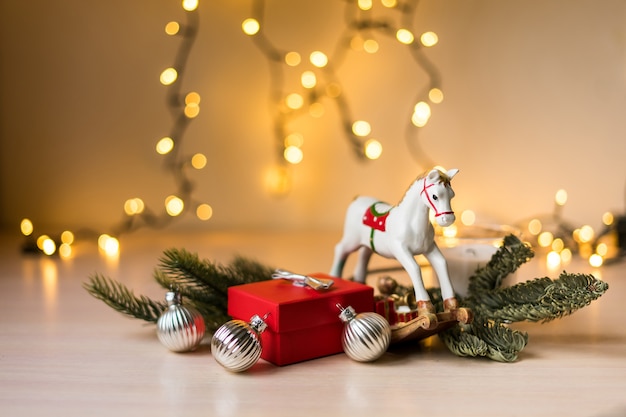 Composizione di Natale e Capodanno. Confezione regalo rossa con luci bokeh dorate dorate, decorazioni natalizie. Foto di alta qualità