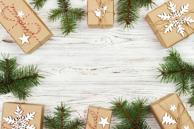 Composizione di Natale, regalo di Natale, coperta lavorata a maglia, pigne, rami di abete su legno bianco