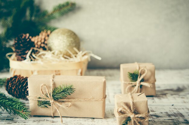 Composizione di Natale Regalo di Natale, pigne, rami di abete su fondo di legno bianco.