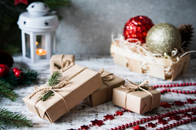 Composizione di Natale Regalo di Natale, pigne, rami di abete su fondo di legno bianco.