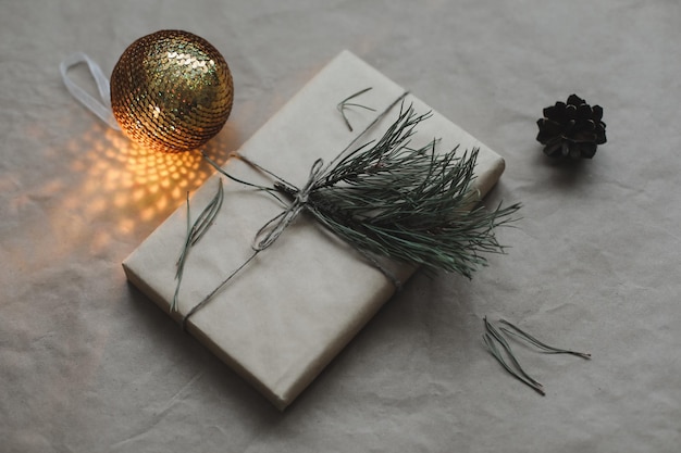 Composizione di Natale su sfondo di carta artigianale con scatola regalo rami di abete giocattoli copia spazio per le tue congratulazioni