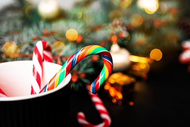 Composizione di Natale. Un albero di Natale decorato con giocattoli e una ghirlanda e un bastone di Natale. Foto di alta qualità