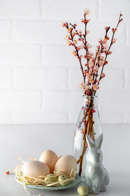 Composizione di Pasqua con fioritura ramo di ciliegio rosa in vaso. Concetto di primavera vacanze di Pasqua. Decorazione tradizionale.