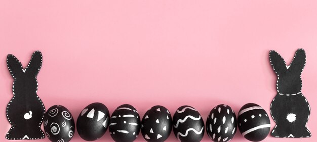 Composizione di Pasqua con le uova e il coniglietto di Pasqua su una parete rosa