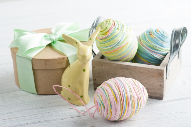 Composizione di Pasqua con regalo, coniglio giocattolo e uova