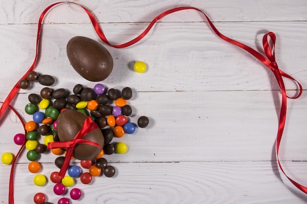 Composizione di Pasqua con uova di cioccolato su fondo di legno bianco Spazio per la copia della vista dall'alto