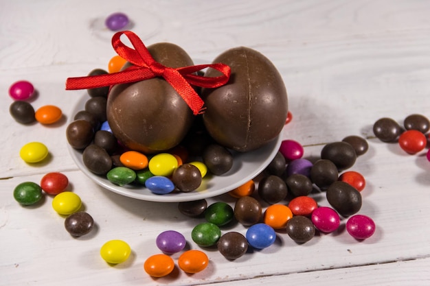 Composizione di Pasqua con uova di cioccolato su fondo di legno bianco