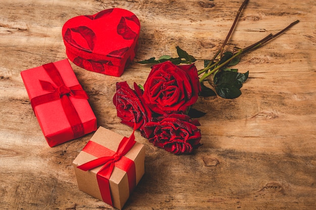 Composizione di rose rosse e scatole regalo