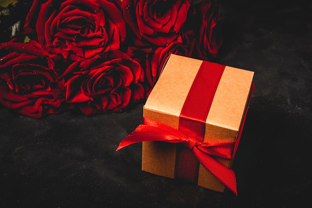 Composizione di rose rosse e scatole regalo