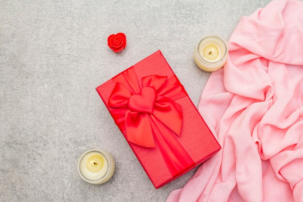 Composizione di San Valentino con confezione regalo rosso, fiori e candele