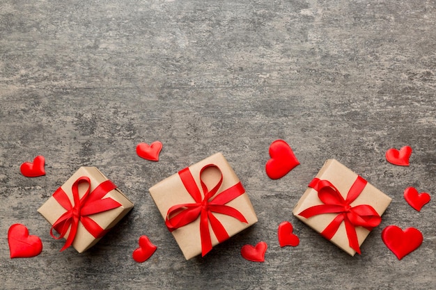 Composizione di San Valentino: confezione regalo rossa con fiocco e cuore. Regalo di Natale. Vista dall'alto. Spazio per il testo. Biglietto di auguri per le feste